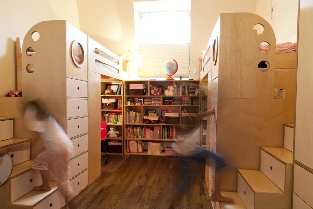 Child’s room with bunk beds, bookshelf, blurred child on swing.