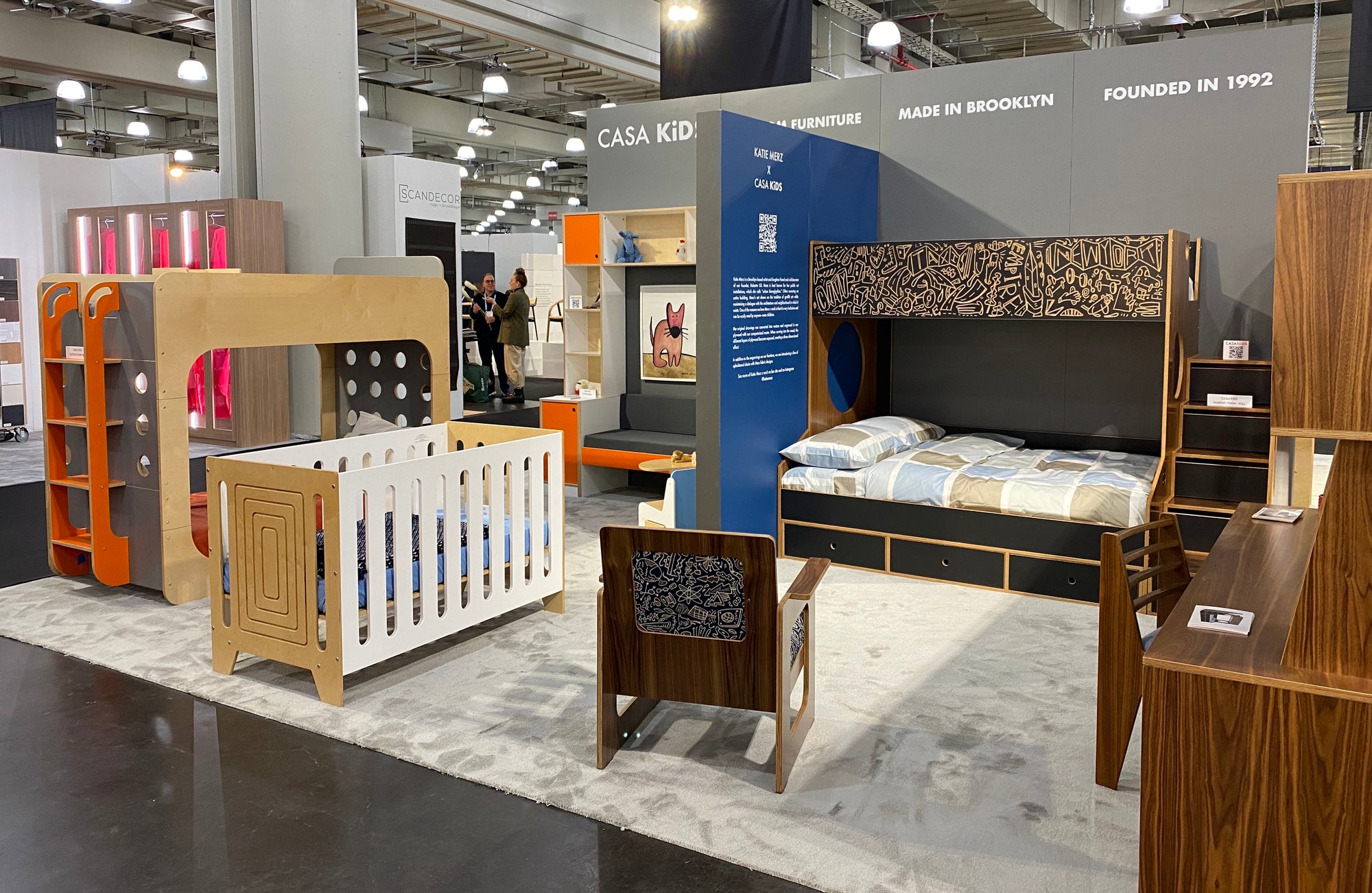 Furniture exhibition booth displaying a variety of modern children's beds and storage solutions.