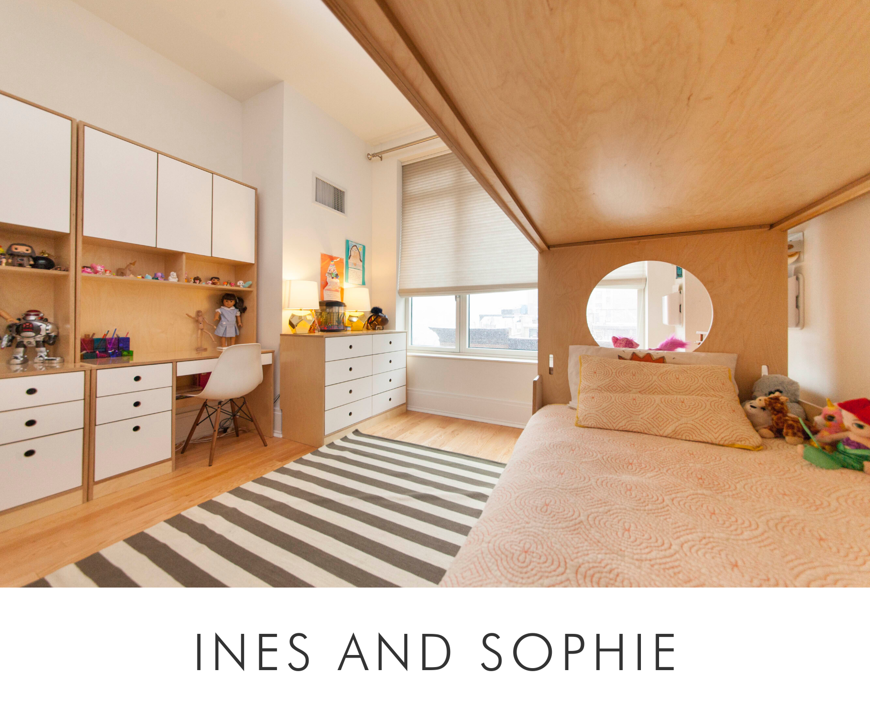 Ines and sophie room bright bedroom with large bed, wooden arch, striped rug, and white cabinetry with toys.