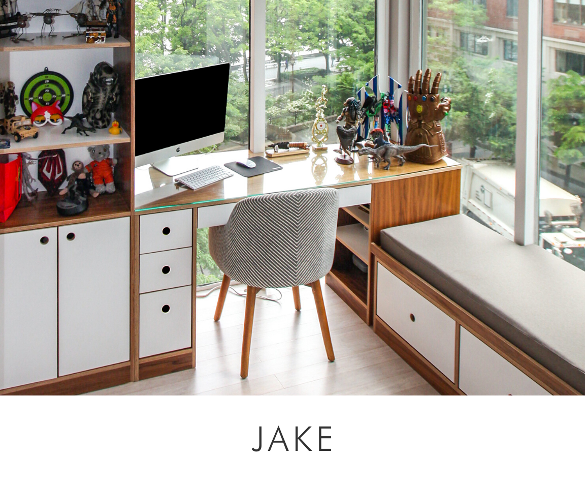 Jake room modern workspace with a monitor, wooden desk, white cabinets, a chair, and various collectibles