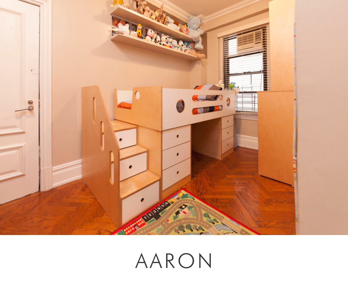 Aaron room kid's play area with a wooden desk, drawers, plush toys on a shelf, and a colorful rug.