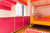 Colorful children’s room with teddy bear, vibrant decor, and bed.