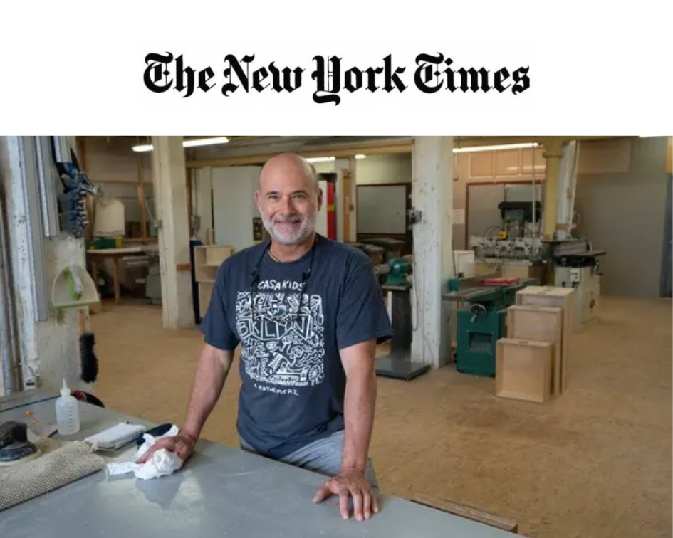 A craftsman smiling in his workshop, featured in The New York Times.