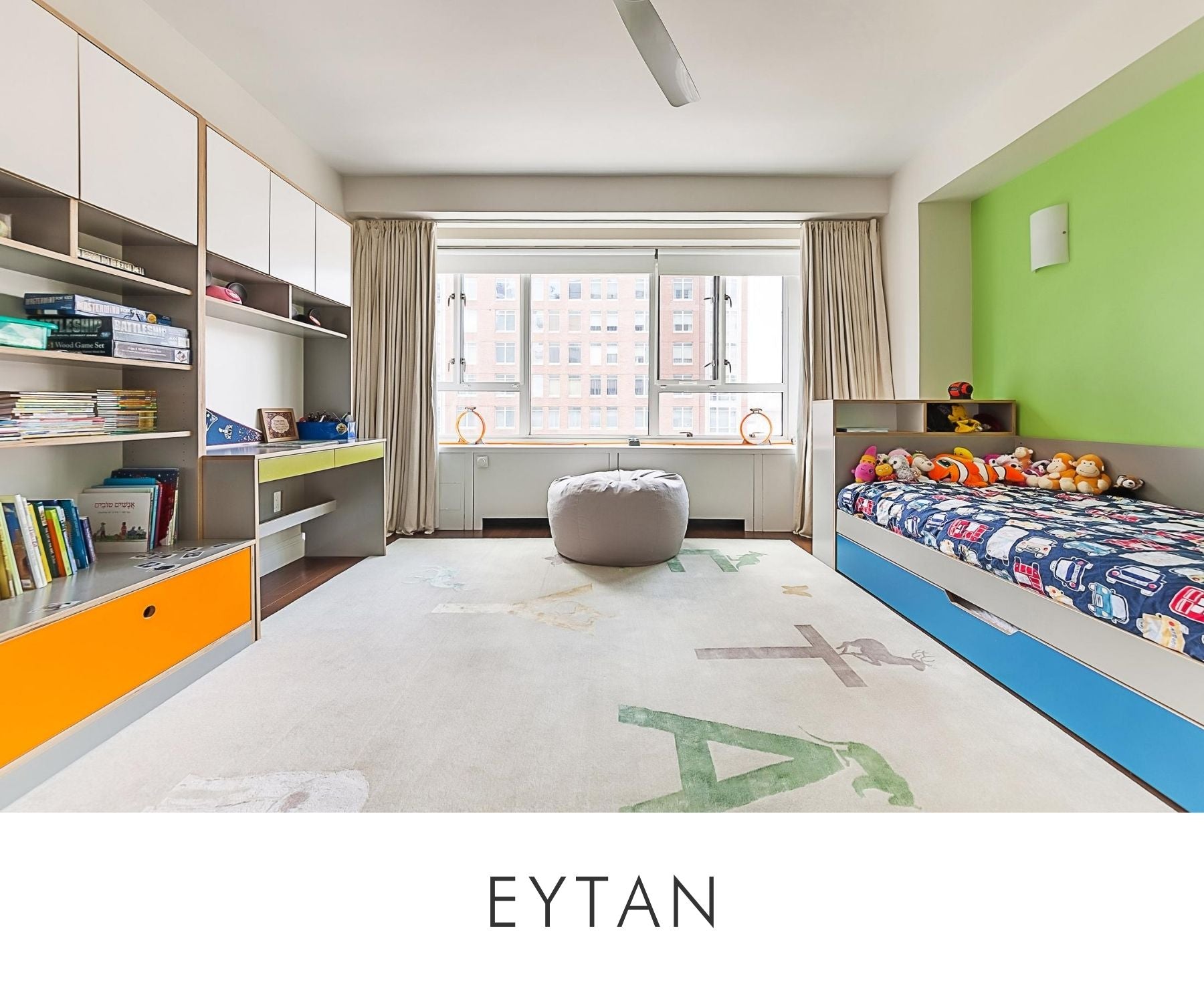 Eytan room bright and colorful child's room with a long bed, playful rug, and extensive shelving.