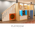 Playroom featuring a large wooden play structure with stairs, shelves, and a play area.