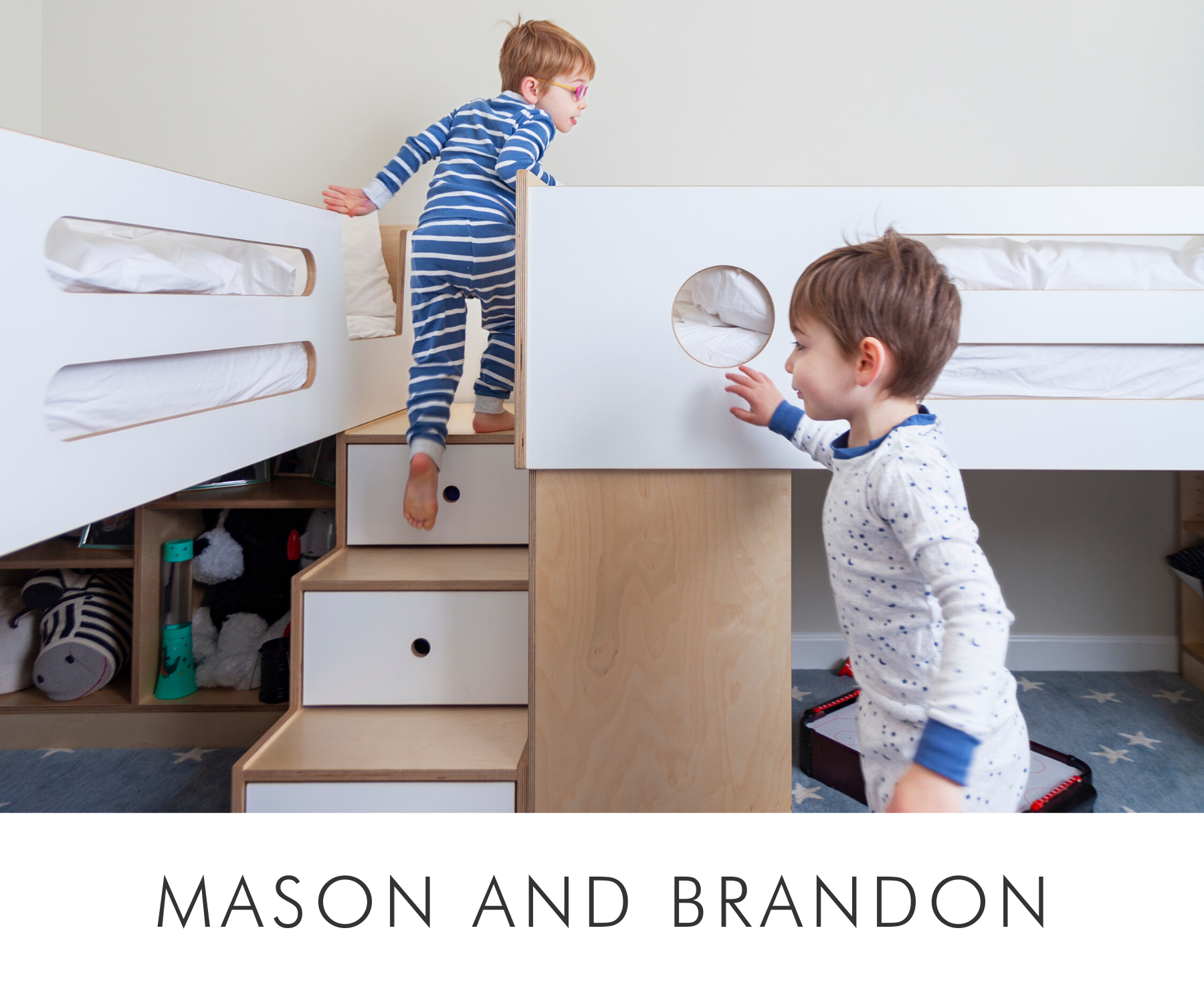 Two young boys playing in a room with a white bunk bed and built-in wooden storage.
