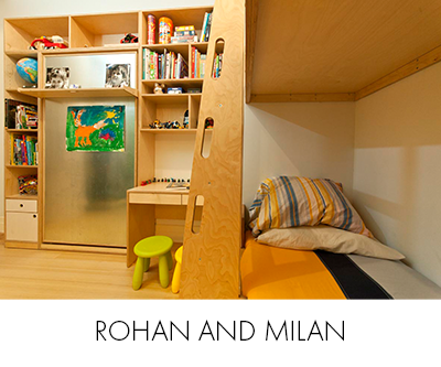 Rohan and milan room compact play space with a yellow bed, wooden shelves, colorful child's artwork, and green stool.