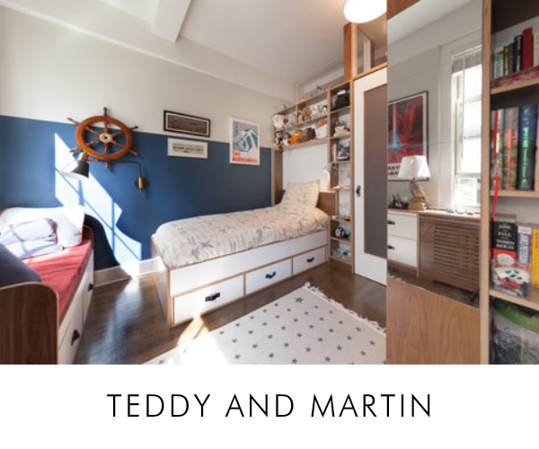Nautical-themed children's room with twin beds, a ship wheel, blue walls, and a spotted rug.