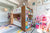 A colorful children's room with a bunk bed, shelves filled with toys and books, a dollhouse, and star-patterned walls.
