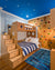 Bedroom with a wooden bunk bed, blue ceiling with stars, rock climbing wall, striped bedding, and a blue striped rug.