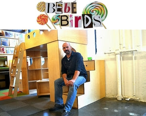 Person sitting in a room with colorful “BE BE BIRDS” wall art.