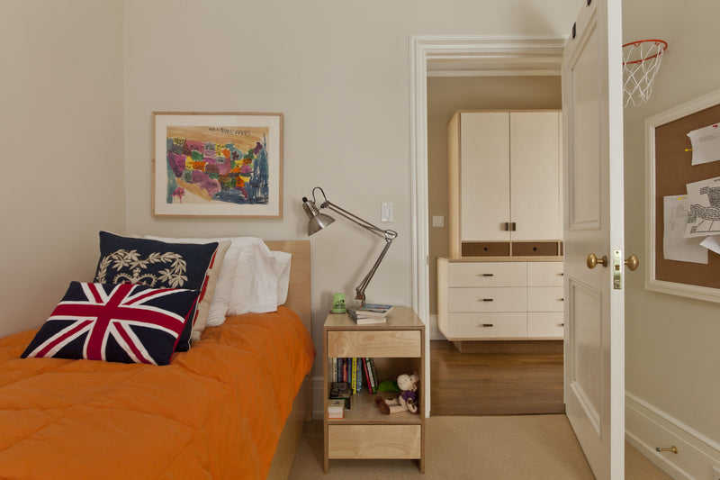Cozy bedroom with white bed, stuffed animals, and magazine on bedspread.
