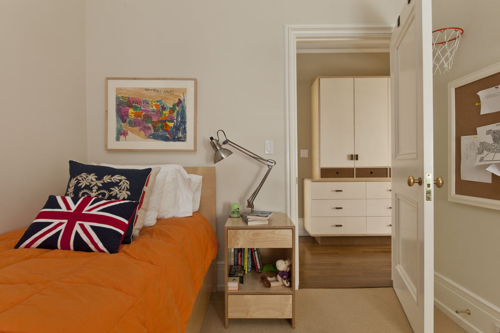Cozy bedroom with white bed, stuffed animals, and magazine on bedspread.