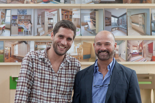 Two individuals in front of a photo montage.