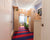 Colorful hallway with striped carpet, wooden furniture, and vibrant decor