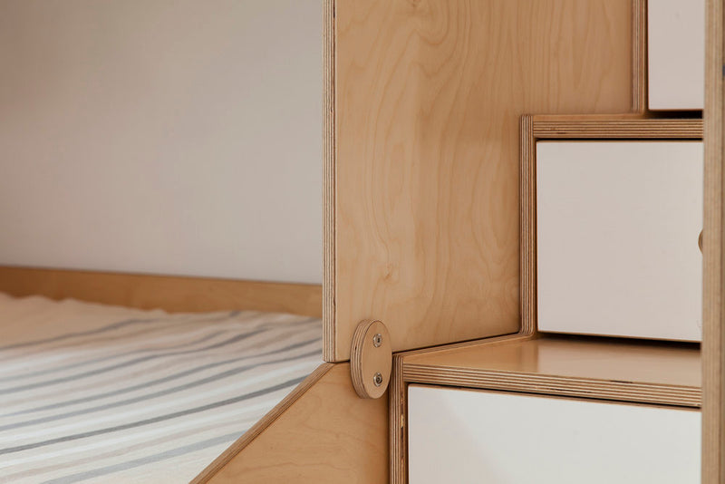 Minimalist wooden furniture, white bedding, blank canvas in a serene space.