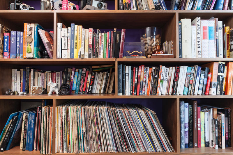 Colorful bookshelf with a variety of books and magazines.