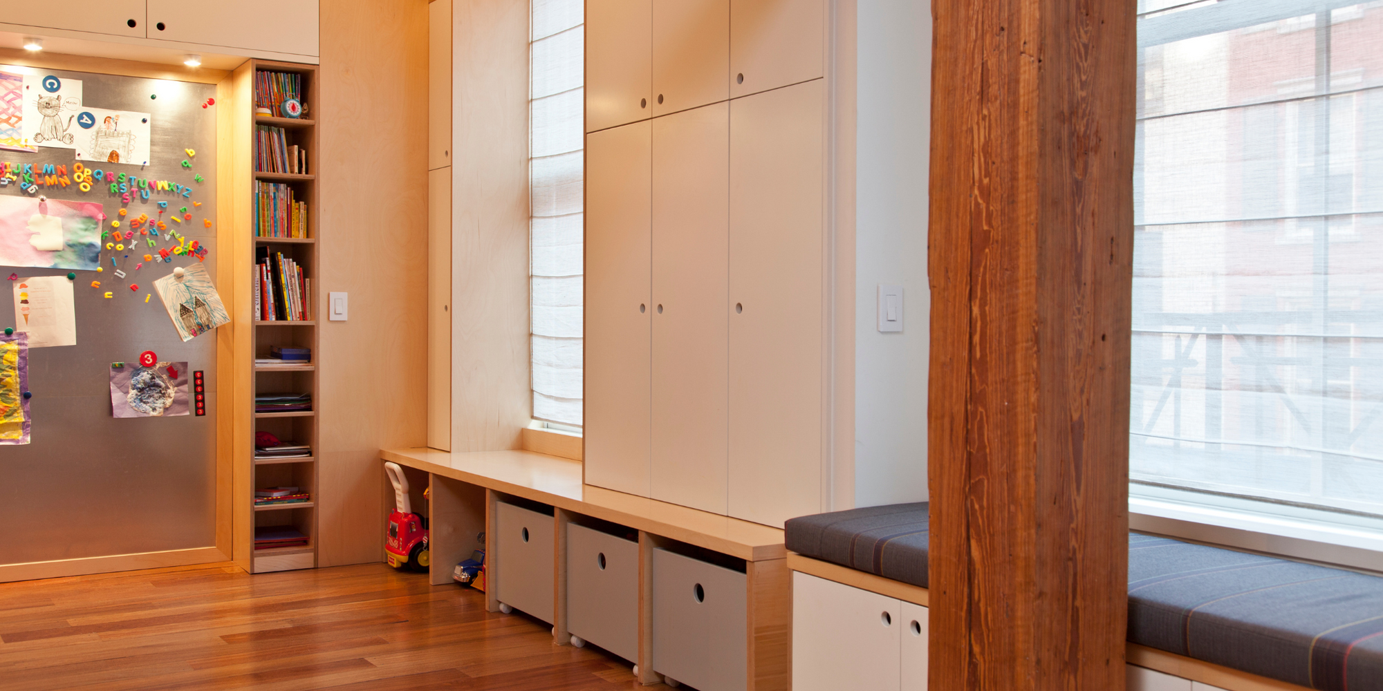 loft space with custom built in cabinetry and bench seating in birch finish with white accents