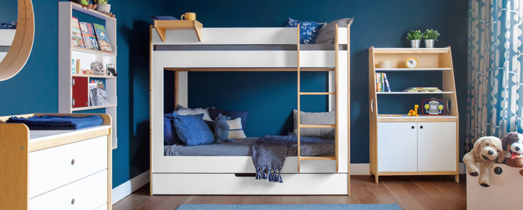 White and birch bunk bed in navy room with dark wood floor, blue rug, and grey bedding with white wall frames