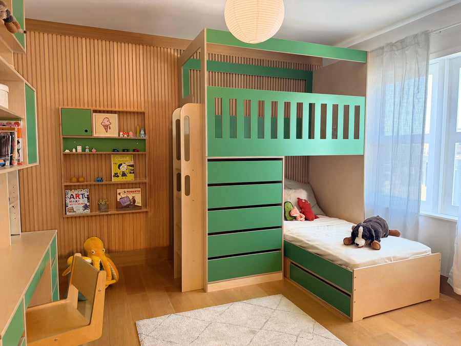 Green bunk bed with lofted play area, built in drawers. embedded wall shelf, and matching desk hutch in light wood kid's room.