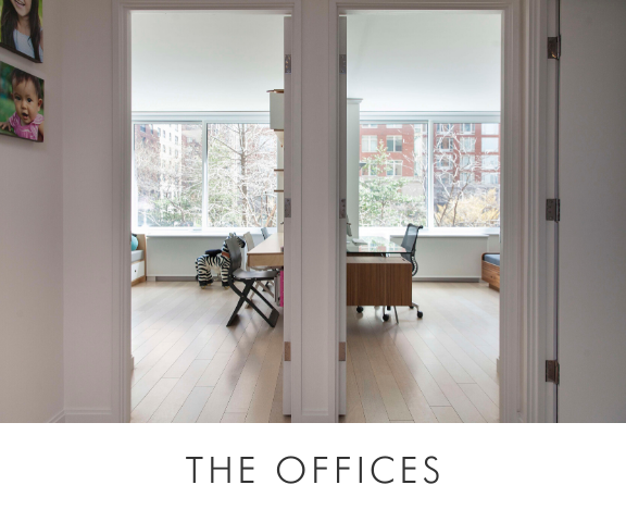 The offices room view through open doors into a bright office with a desk, chair, large windows, and light wood floors.