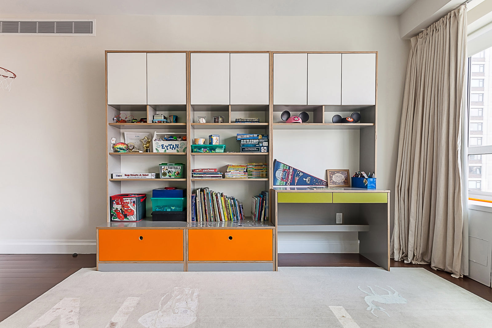 Modern room with shelving, desk, colorful bins, and books.