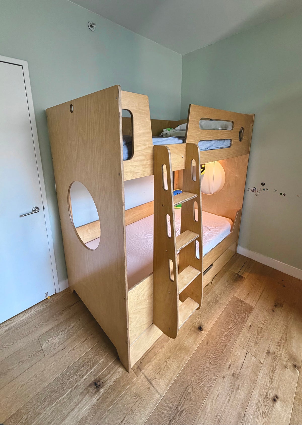 Side view of pre-owned Marino bunk bed in birch with round cutout panel and ladder