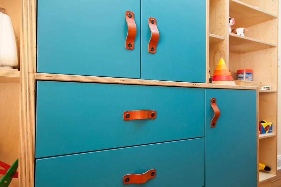 Blue cabinet with orange handles among children’s toys.