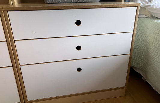 White dresser with three drawers in a room setting