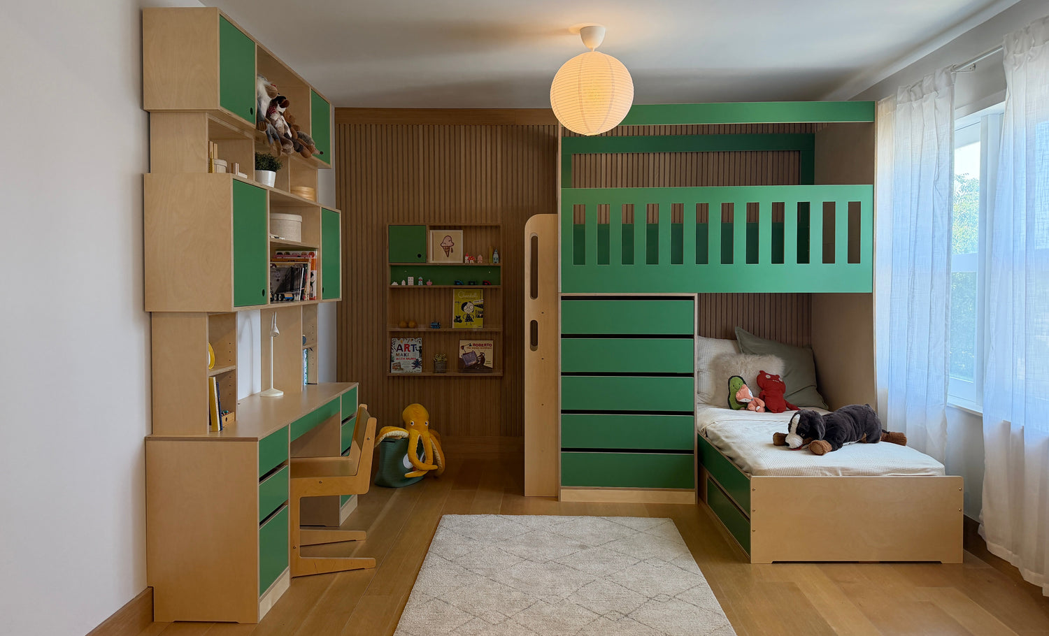 Custom Green desk with tall hutch, built in shelf on the wall, adn L shaped bunk bed with top bunk play area with tall rails and bottom twin bunk for sleep.