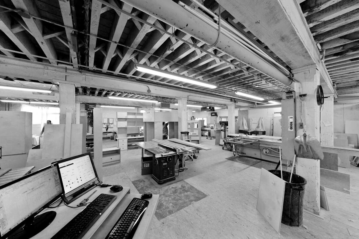 Black and white photo of a spacious, modern industrial workshop with various equipment.
