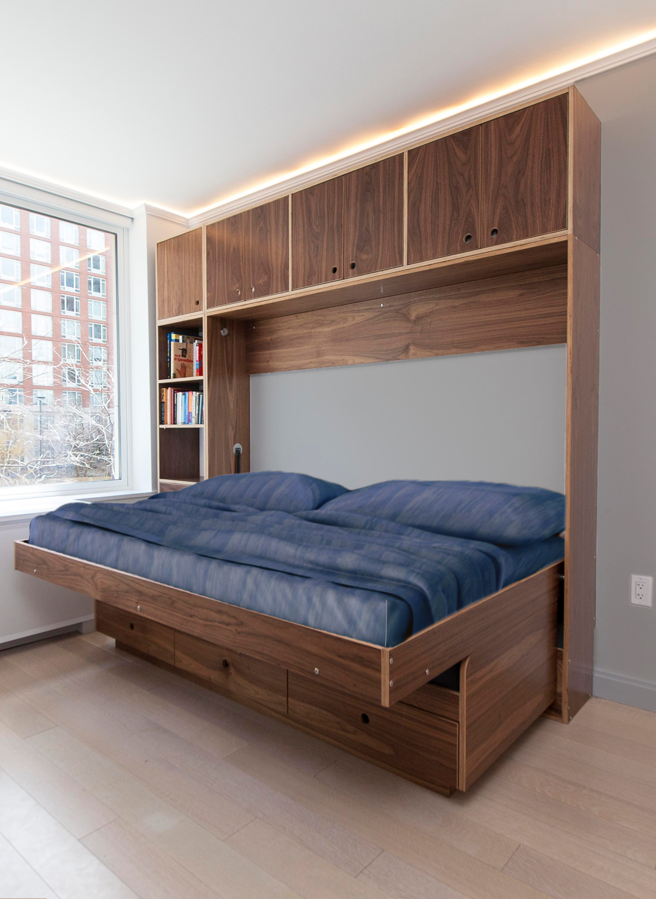 Sleek bedroom with a large wooden bed, overhead storage, and a view of the city through the window.