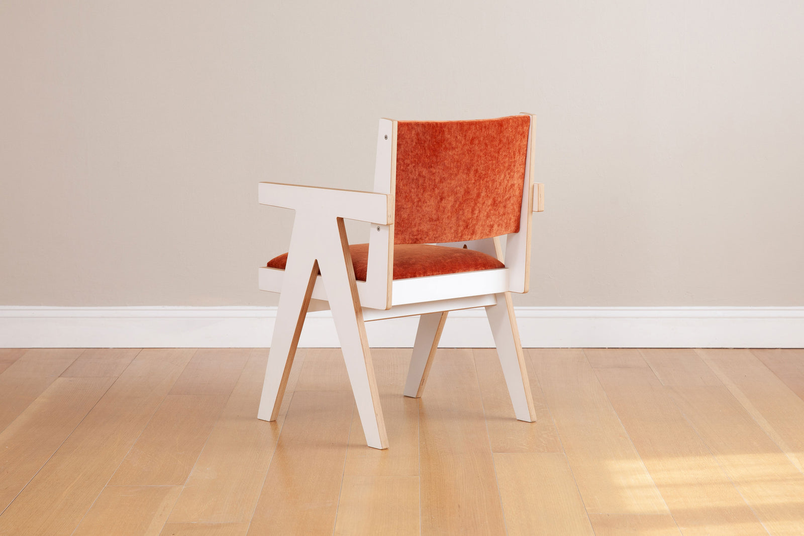 white armchair with custom orange upholstery back view