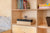 Birch cabinet with books, games, and storage space, located next to a bed in a children's room.

