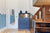 Blue dresser with a reptile tank on top, next to a walnut staircase leading to a loft bed in a children's room with blue wave-themed walls.

