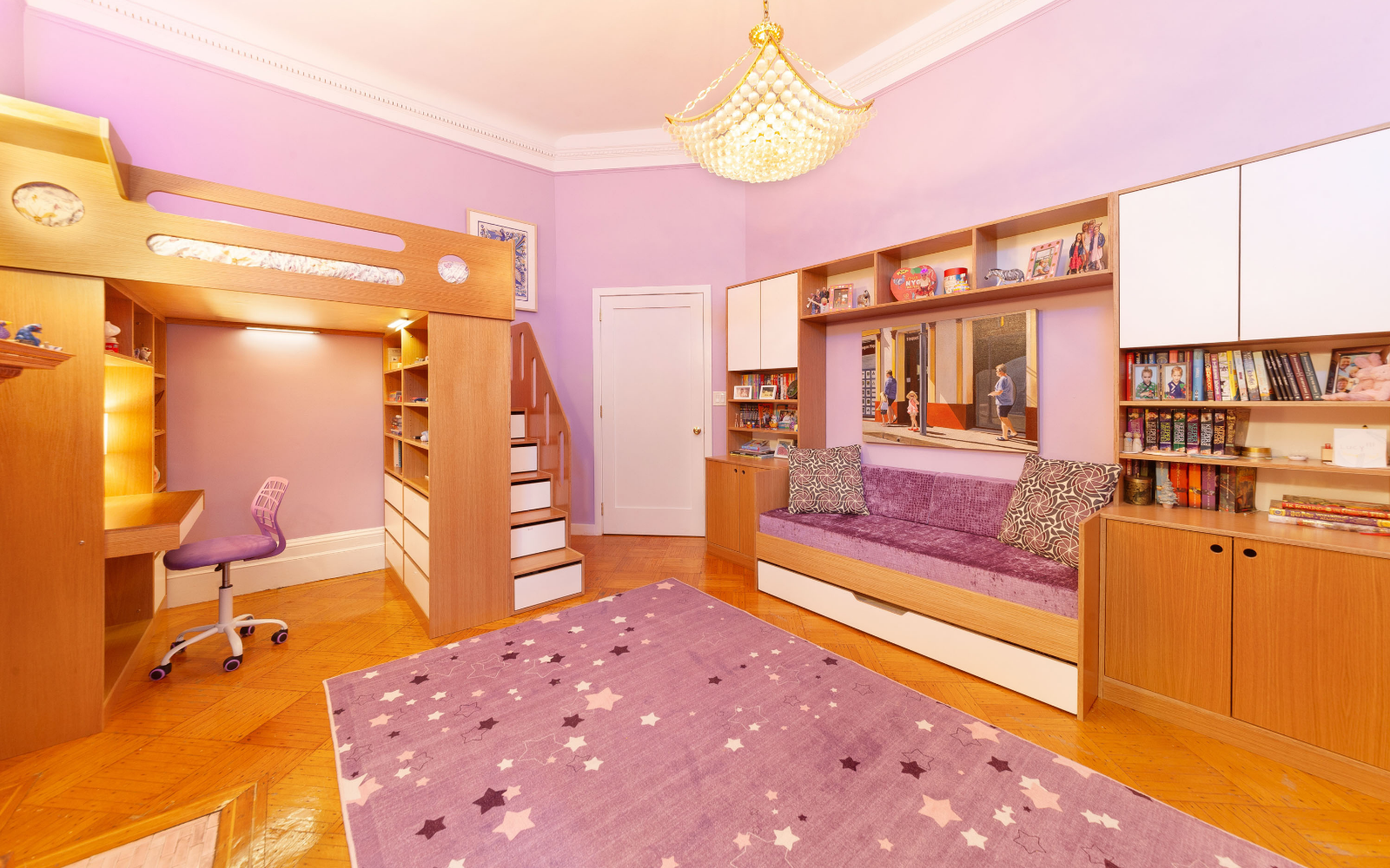 Custom room setup featuring a Cabina bunk bed in white and natural wood finish, paired with a built-in desk and storage units. The bunk bed includes an integrated ladder and open shelving at the top. Adjacent to the bunk is a spacious built-in desk with shelves above, organized with toys, books, and other items. The room also features ample wardrobe and drawer storage, providing a clean and functional layout ideal for a child’s bedroom with study and play areas.






