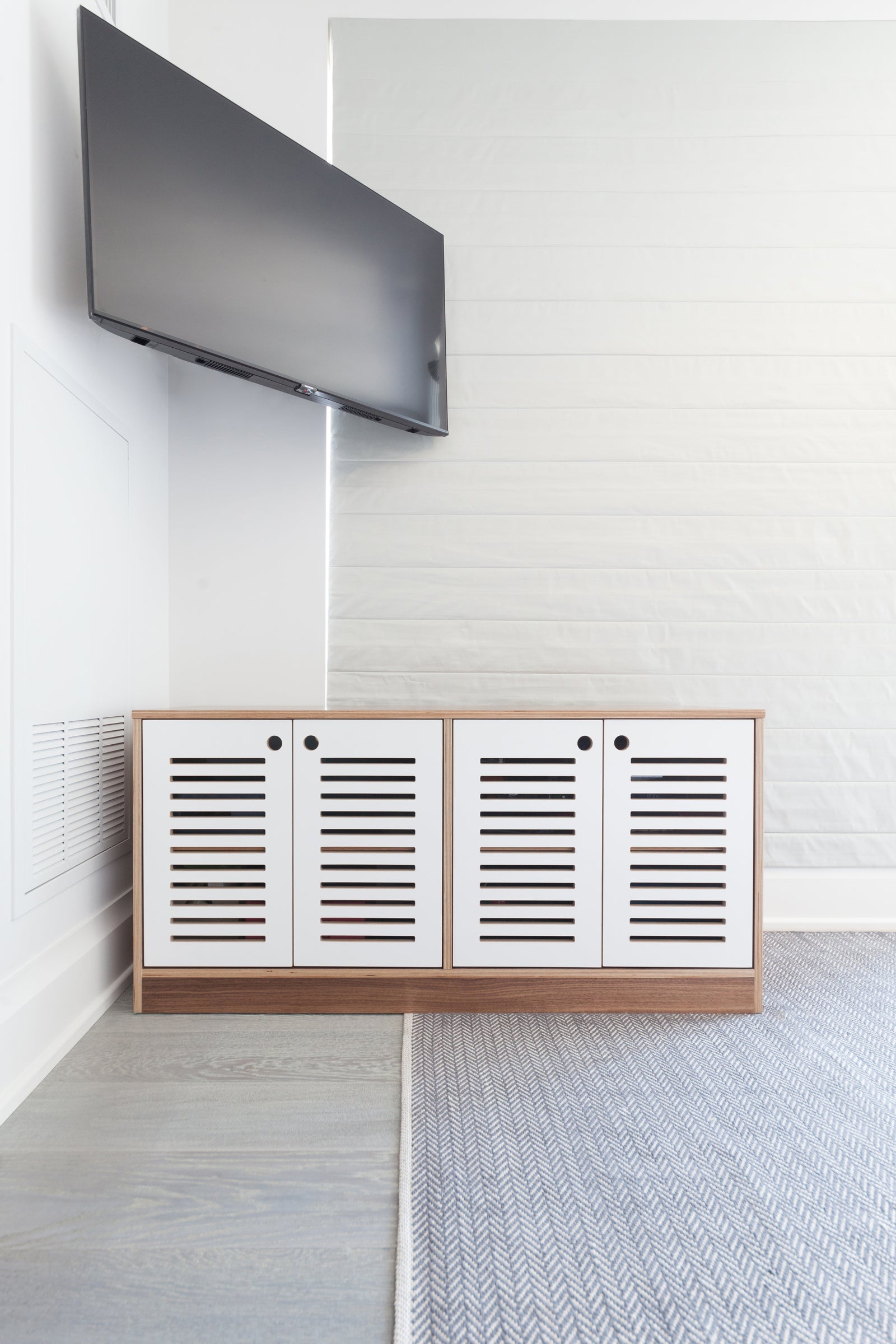 Cabinet with slotted doors designed to allow operation of a game system and TV box while ensuring proper ventilation.

