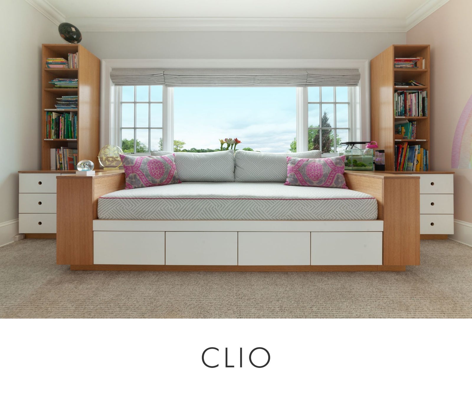 Close-up view of custom oak and white window bench with built-in daybed and under-seat storage drawers, flanked by tall bookcases and cabinetry — a bright, functional kids’ room design.