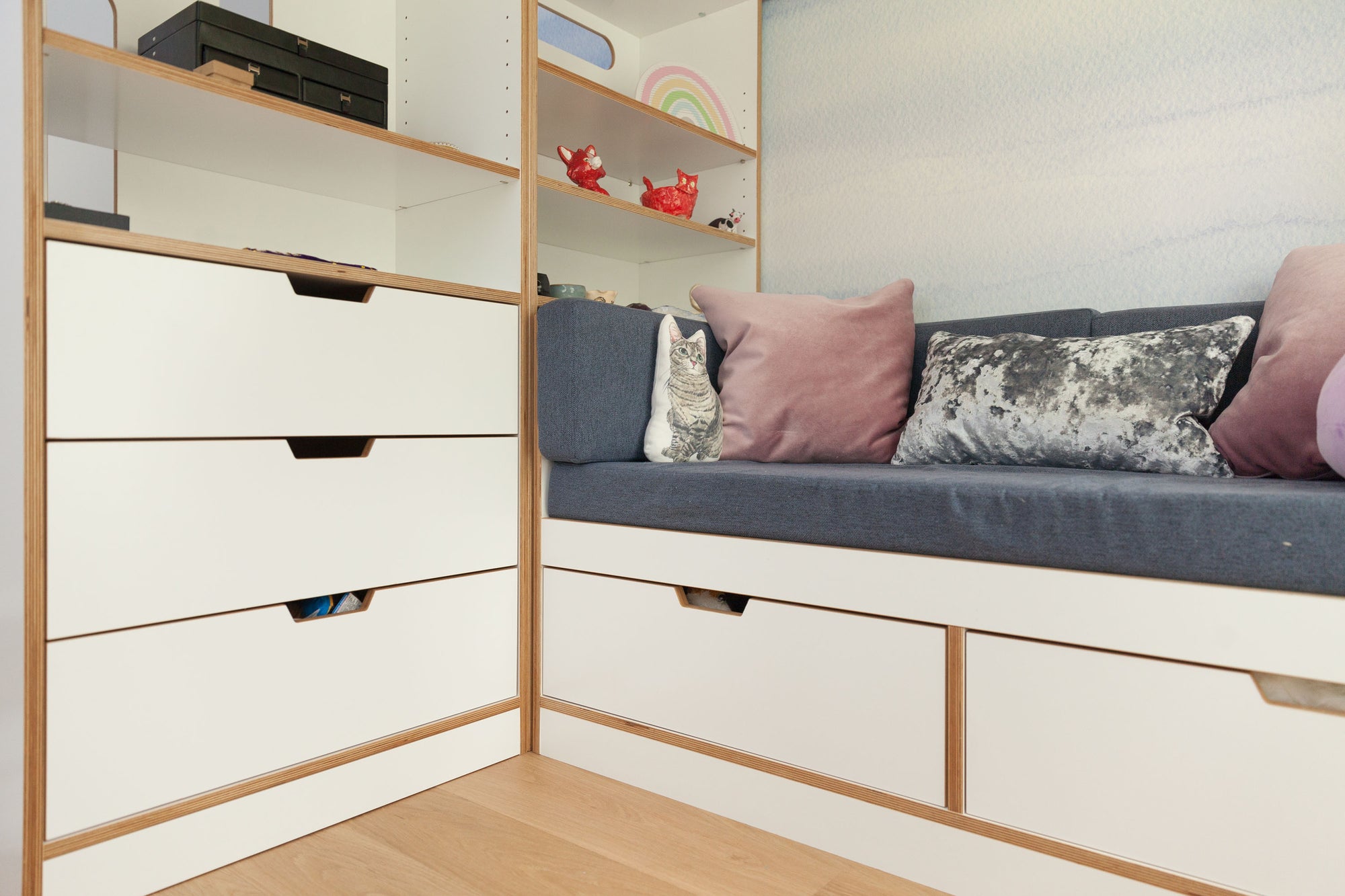 White dresser with open storage and seating area, featuring drawers below the seat, located under a loft bed.

