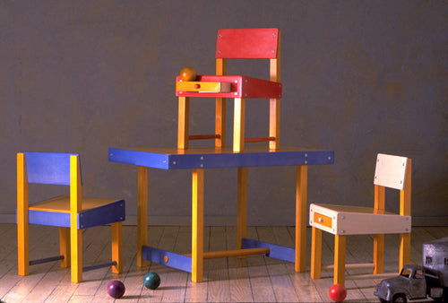 Colorful kids' play table set with three matching chairs, featuring a minimalist wood design for a creative playroom.
