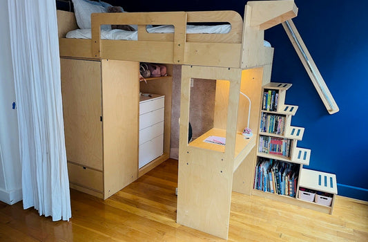 light wooden loft bed with slide in a room with blue walls and wooden floor.