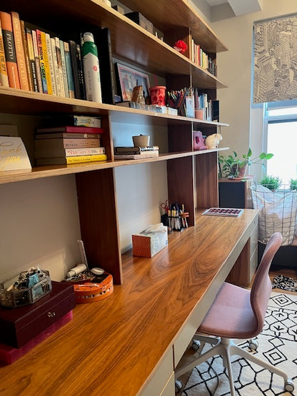 wooden desk and large shelf unit with books, side view of the workspace