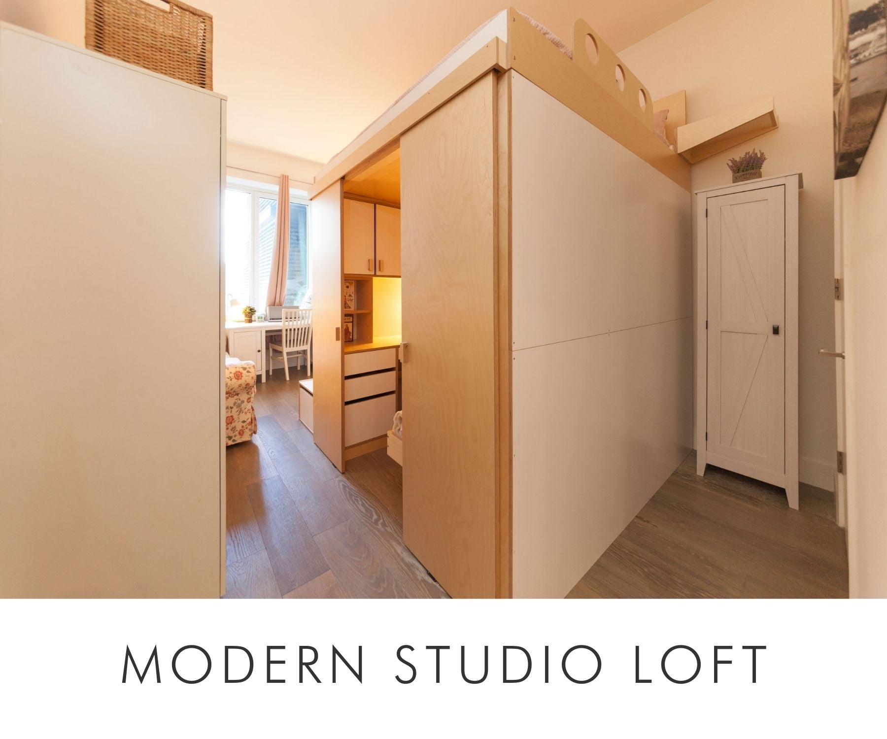 Custom king-size loft bed with built-in storage and workspace underneath in a modern studio apartment. Birch plywood finish with white accents.