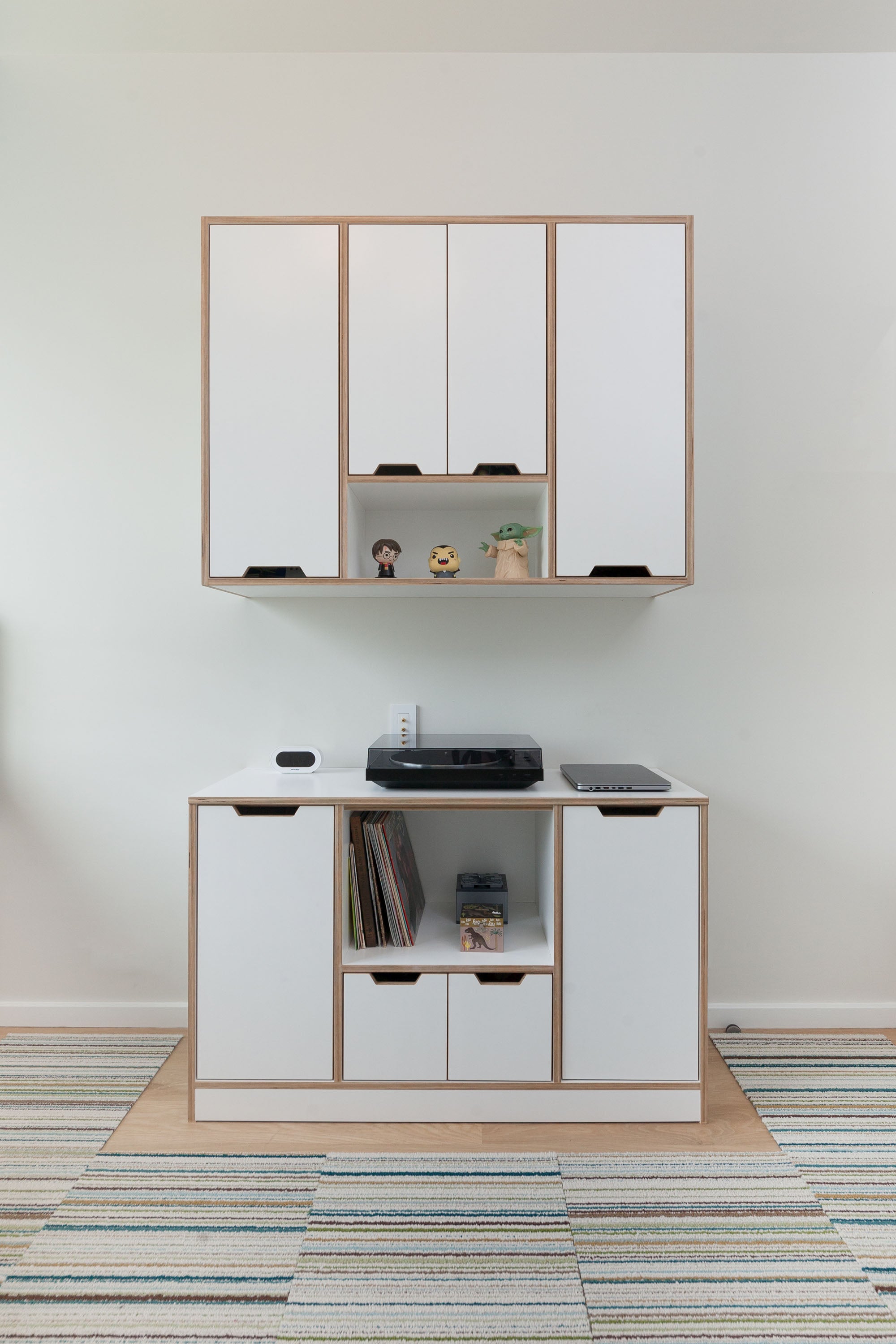 White media storage cabinet with upper and lower shelving, featuring space for records and a turntable in a minimalist design.

