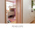 View through custom birch and white cabinetry into child's bedroom featuring a built-in loft bed, desk, and colorful rug.