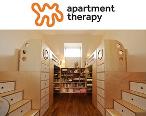 Cozy reading nook with built-in bookshelves and drawers under a window