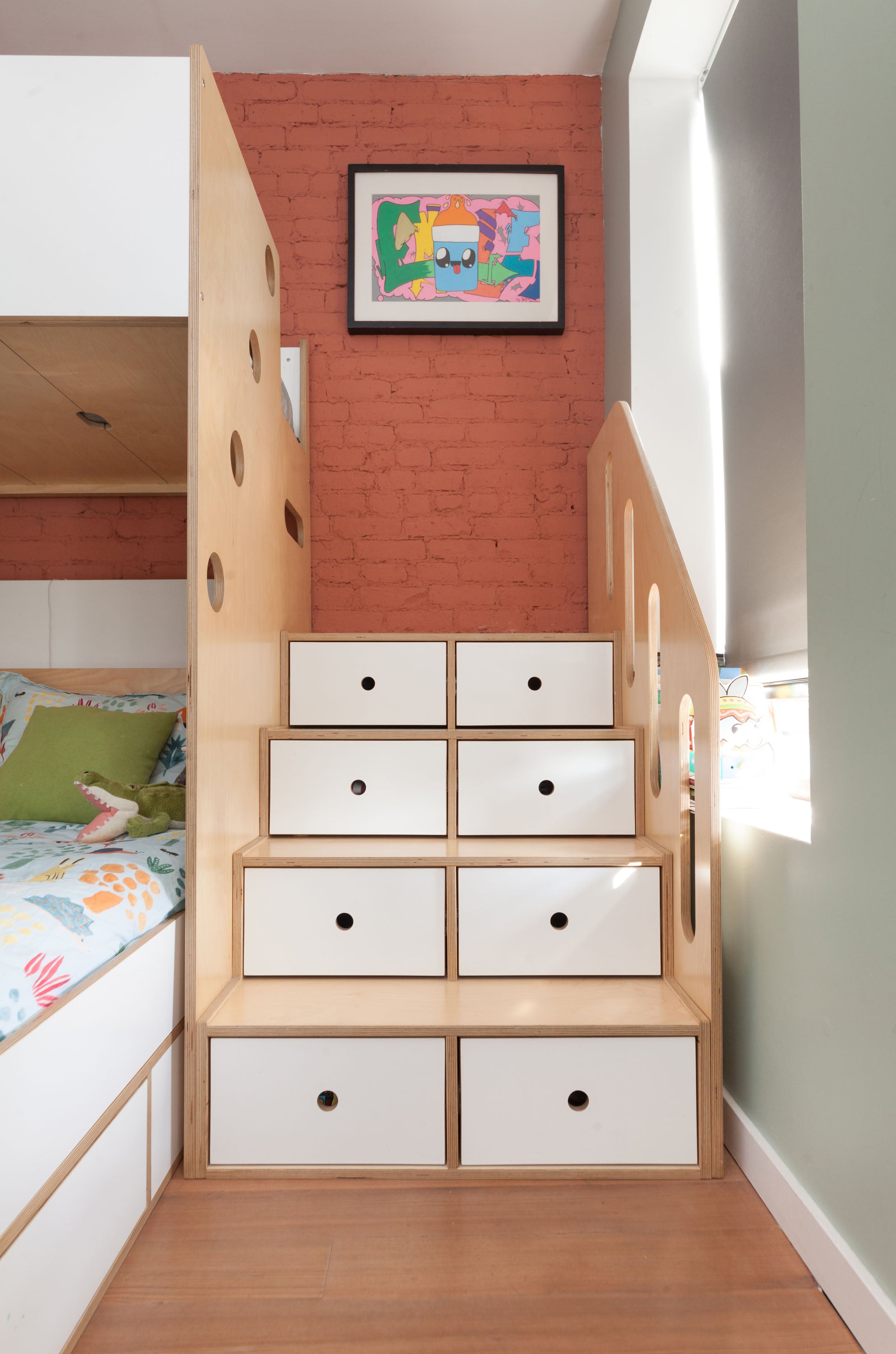 Storage staircase with built-in drawers leading to a bunk bed, featuring a natural birch finish with white drawer fronts.

