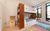 Bunk bed with a rich walnut finish, featuring a built-in bookshelf at the head of the bed. The bunk bed includes a cozy lower bunk with storage drawers underneath and a ladder with rounded cutout details on the side. The room is bathed in natural light from large windows, and a colorful geometric-patterned rug adds a playful touch to the space. An art station with a roll of paper and a storage box is placed beside the bed, enhancing the room's functionality for both sleeping and creative activities.






