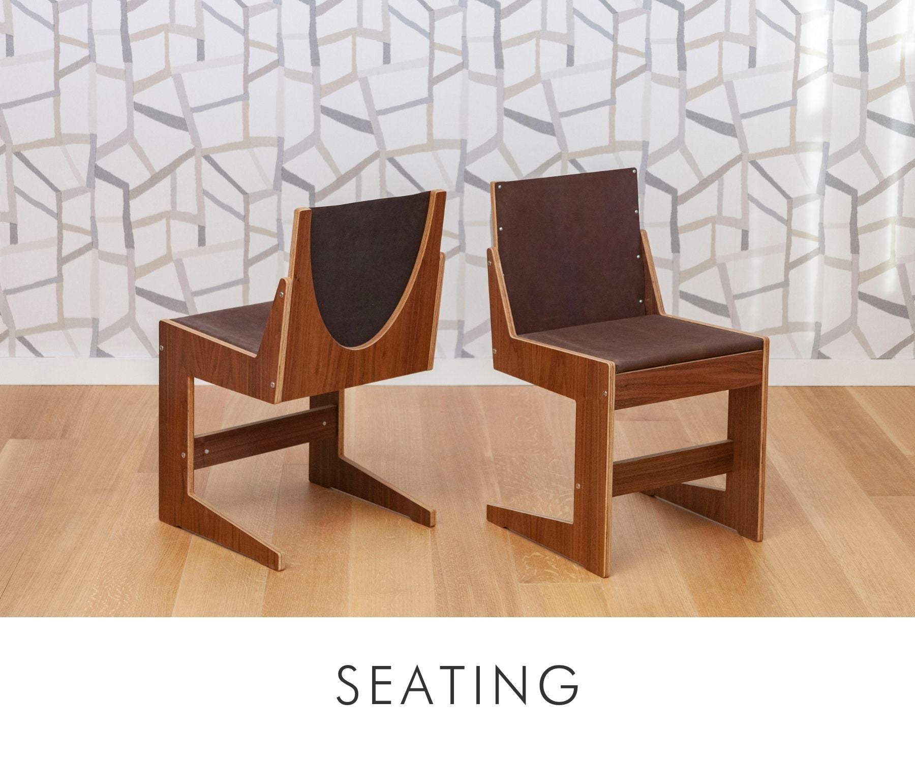 Pair of modern walnut chairs with brown leather seat and backrest, featuring a sculptural design with a geometric frame.