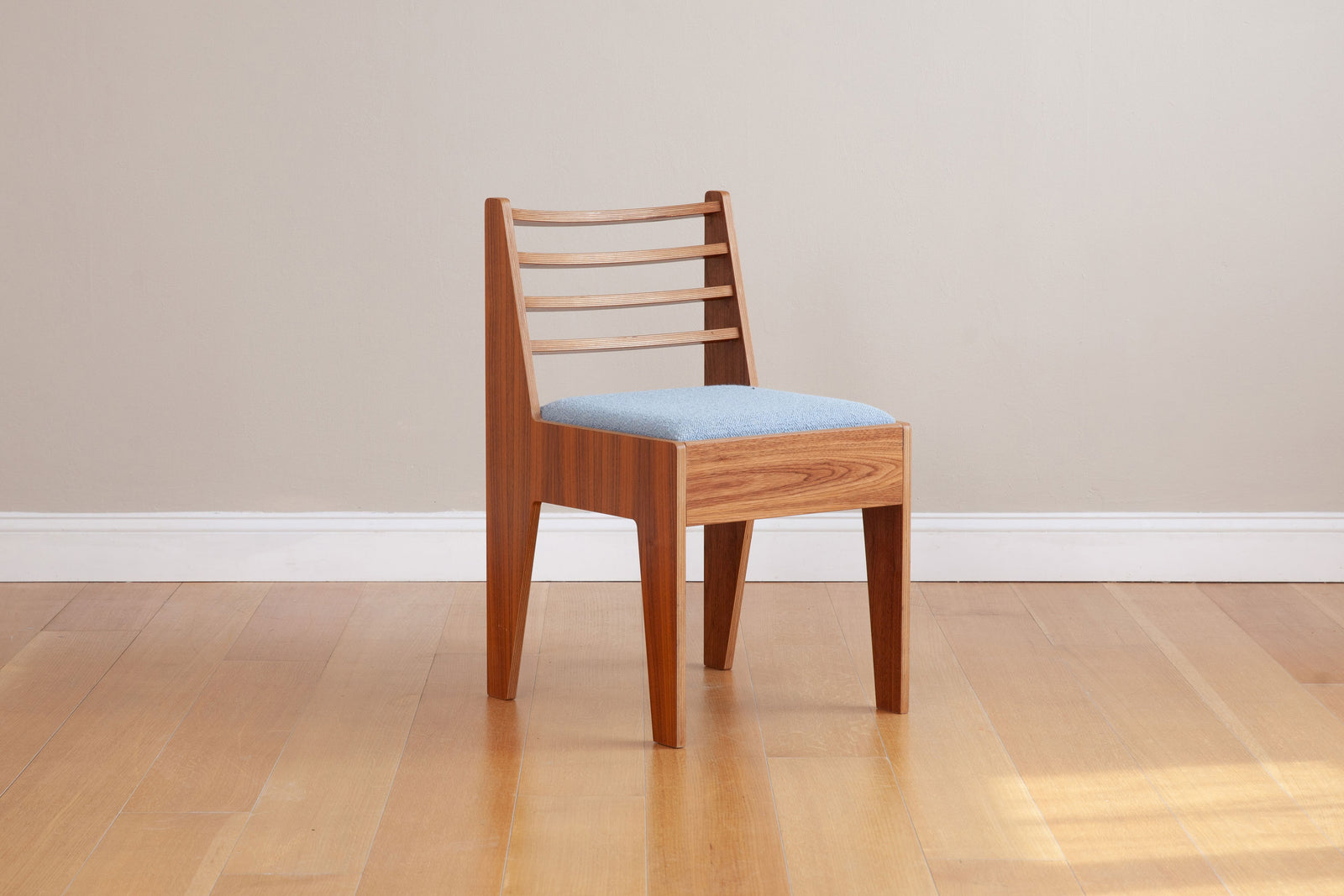front view of walnut dining chair with light blue upholstery